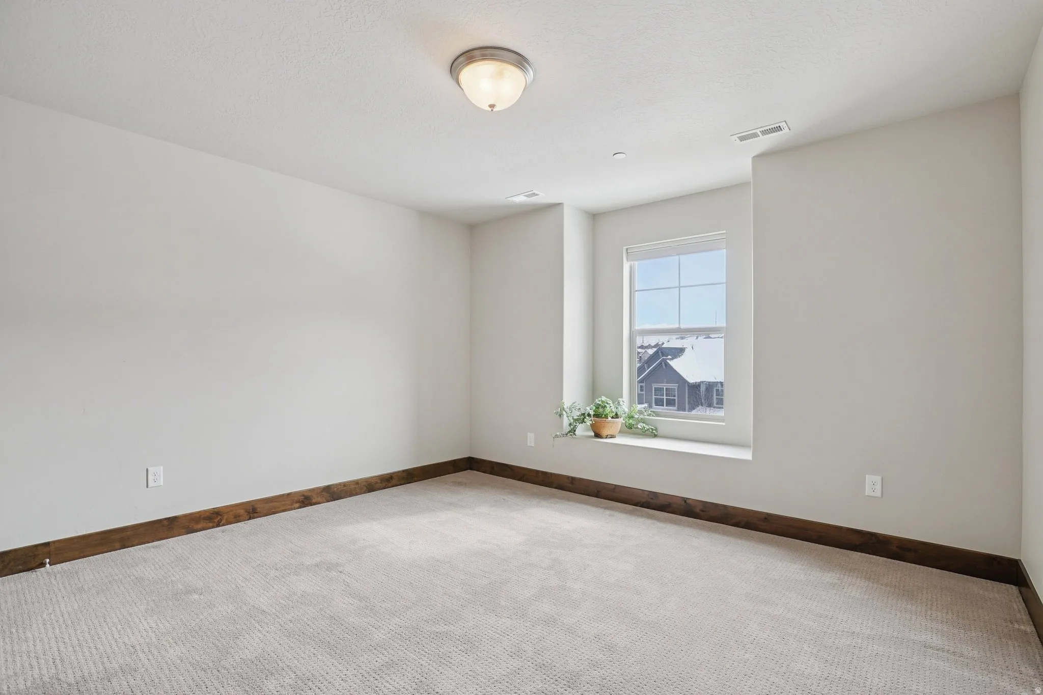 Carpeted spare room with baseboards