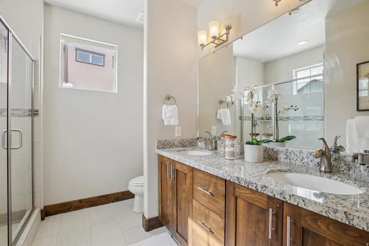 Full bath with double vanity and a stall shower