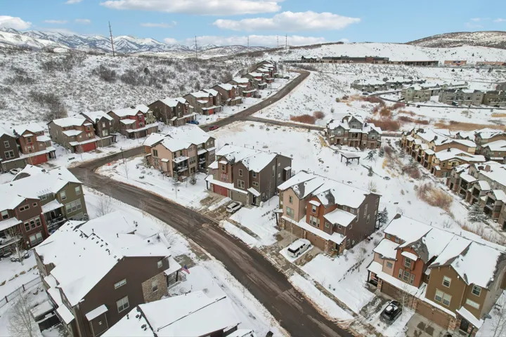 Snowy aerial view featuring a mountain view and a residential view