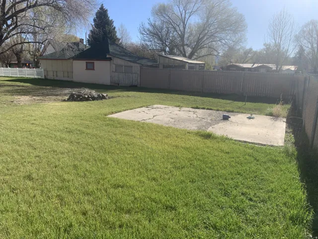 Expansive grassy yard with a concrete patio area