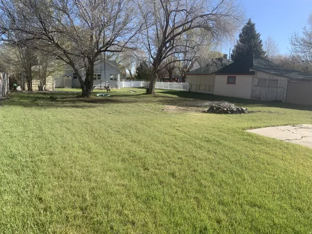 Expansive lawn area with mature trees providing natural shading