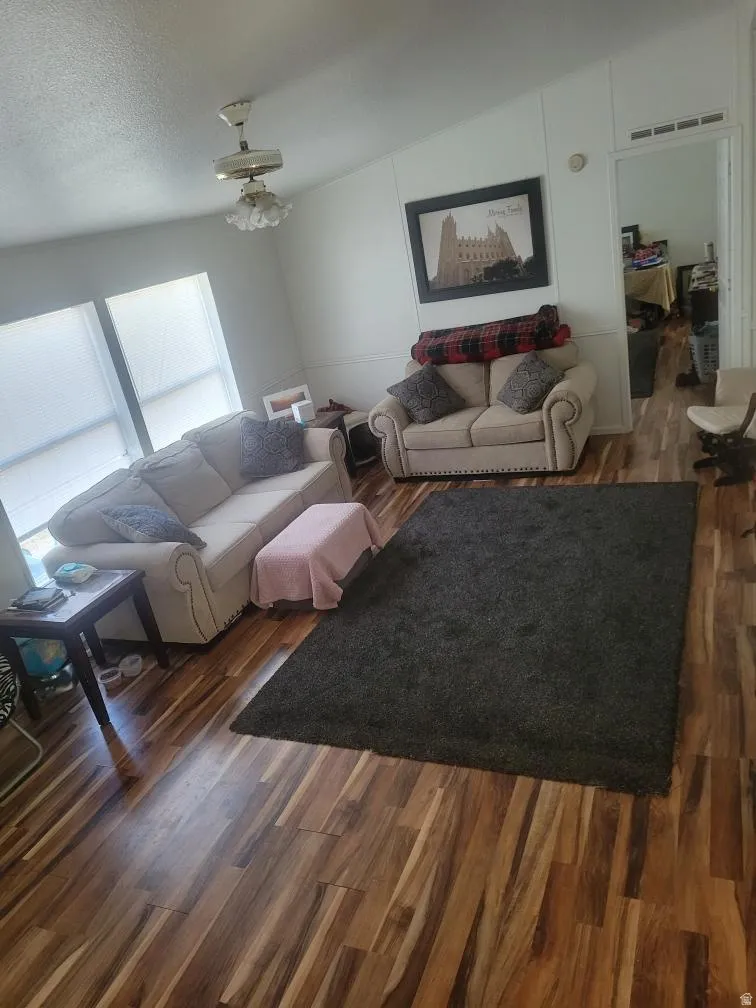 Living room with dark wood-style floors and a textured ceiling