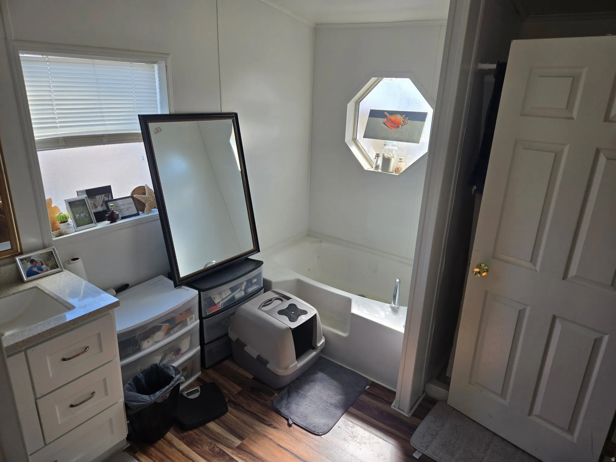 Bathroom featuring a bath, vanity, and dark wood-style floors