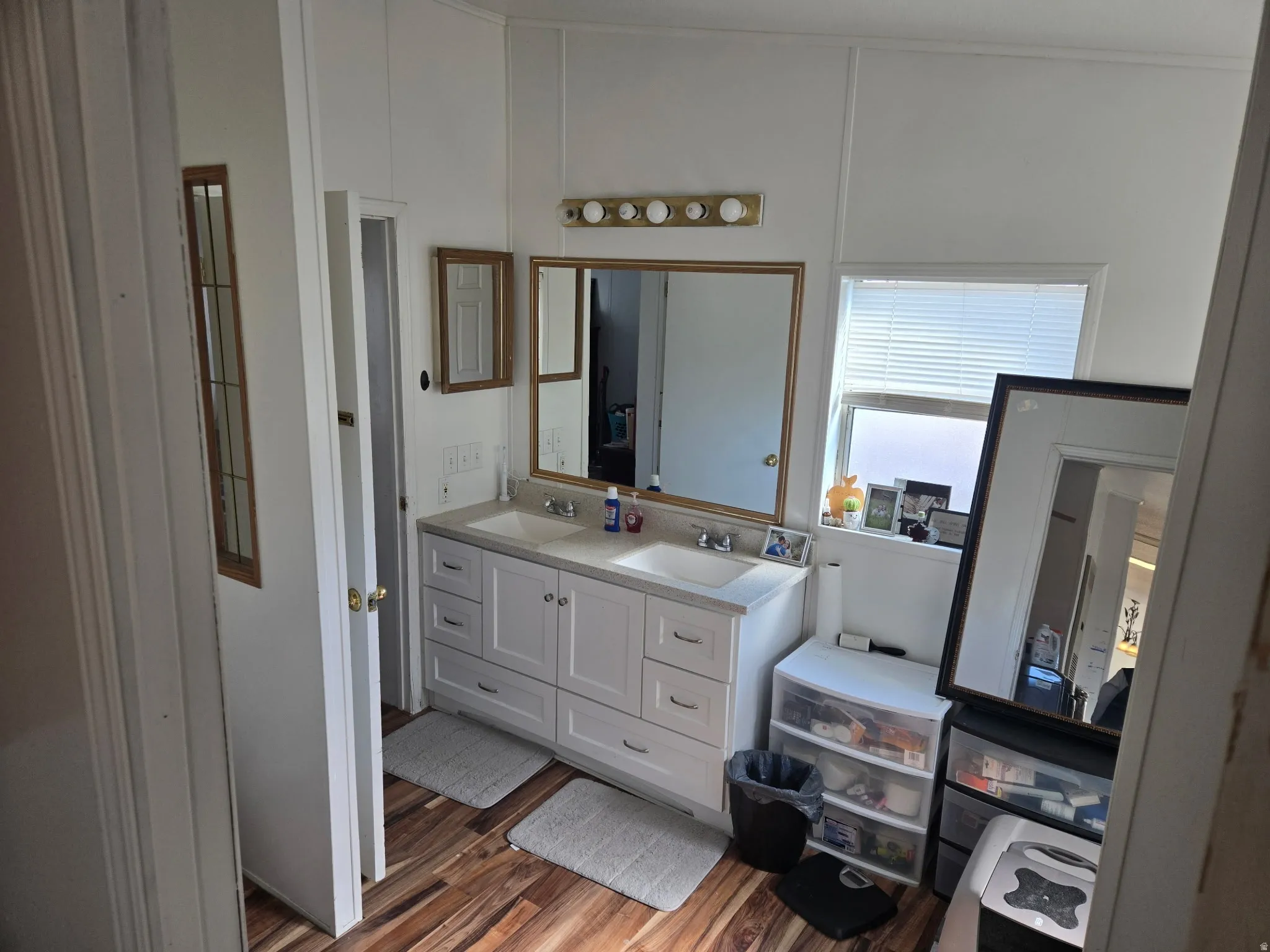 Bathroom with double vanity and dark wood finished floors