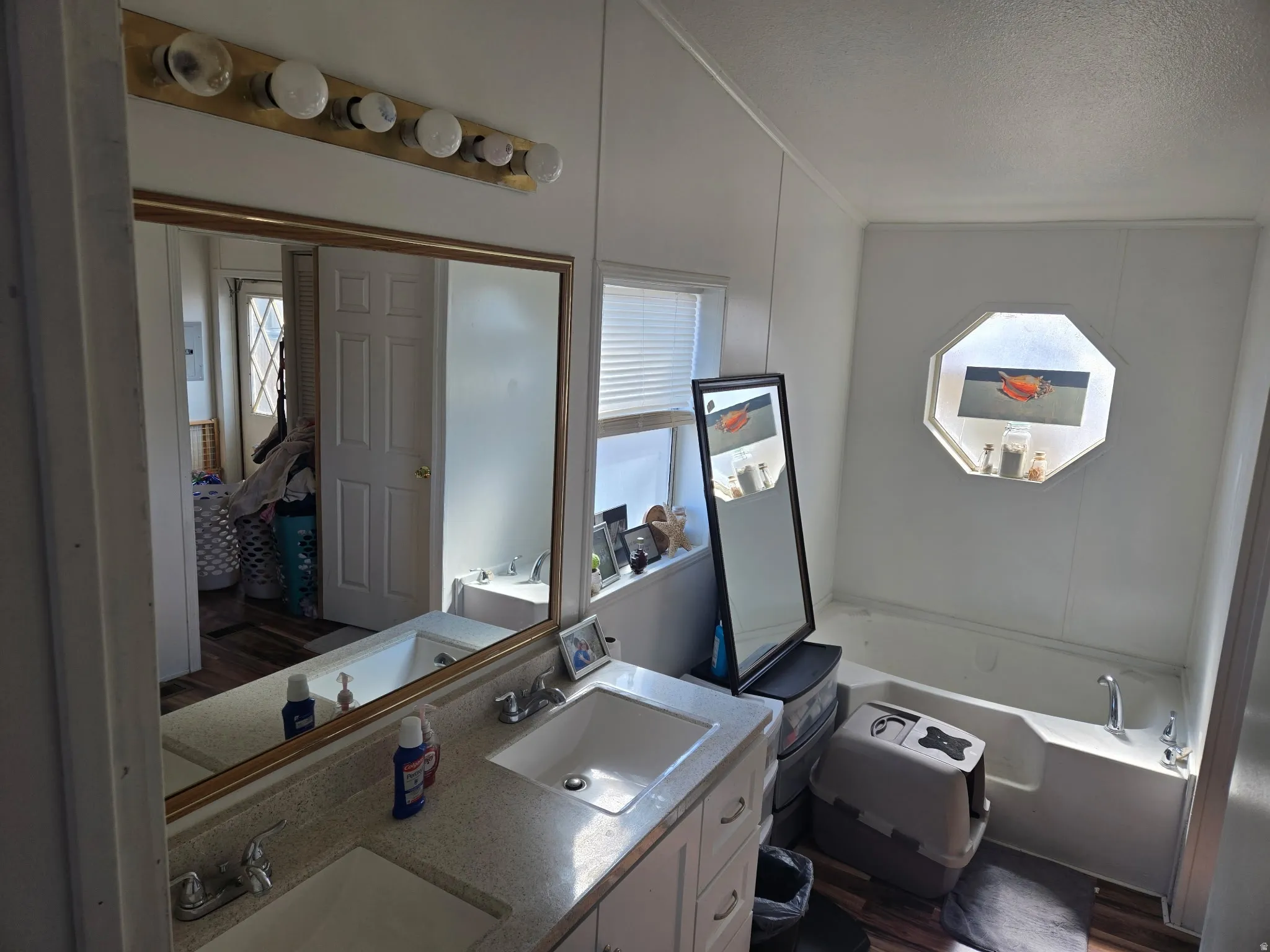 Full bathroom with double vanity, a garden tub, plenty of natural light, a textured ceiling, and ensuite bath