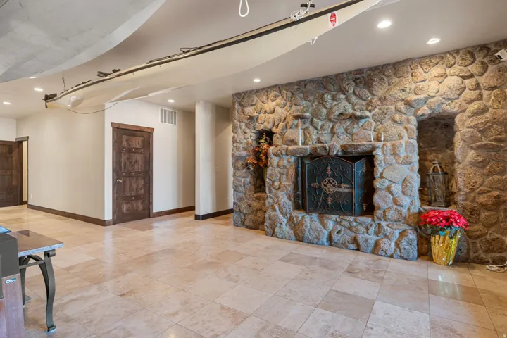 Unfurnished living room featuring recessed lighting and a stone fireplace