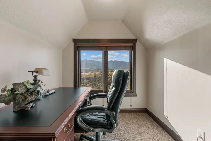 Office featuring a textured ceiling, light colored carpet, and a mountain view