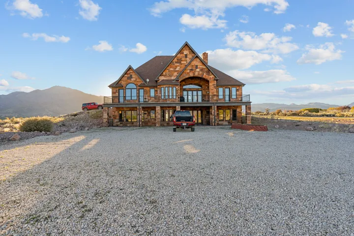 View of front of house with a mountain view, stone siding, and a chimney