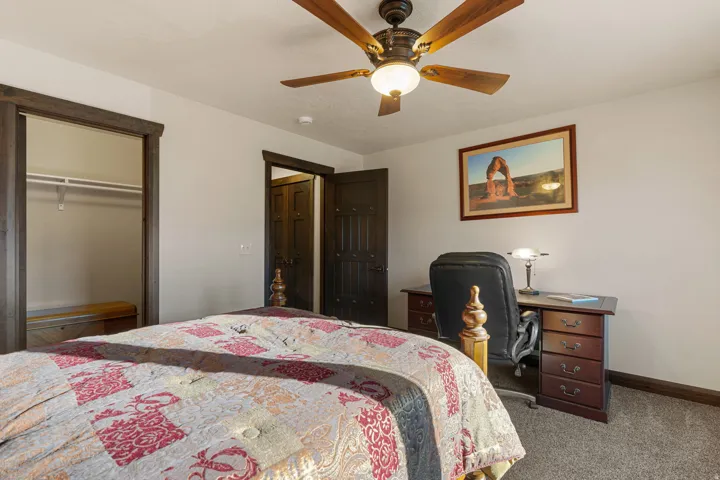 Carpeted bedroom with a closet and ceiling fan