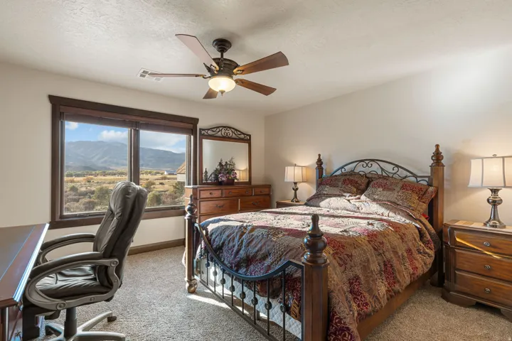 Bedroom with a mountain view, a textured ceiling, carpet floors, and ceiling fan