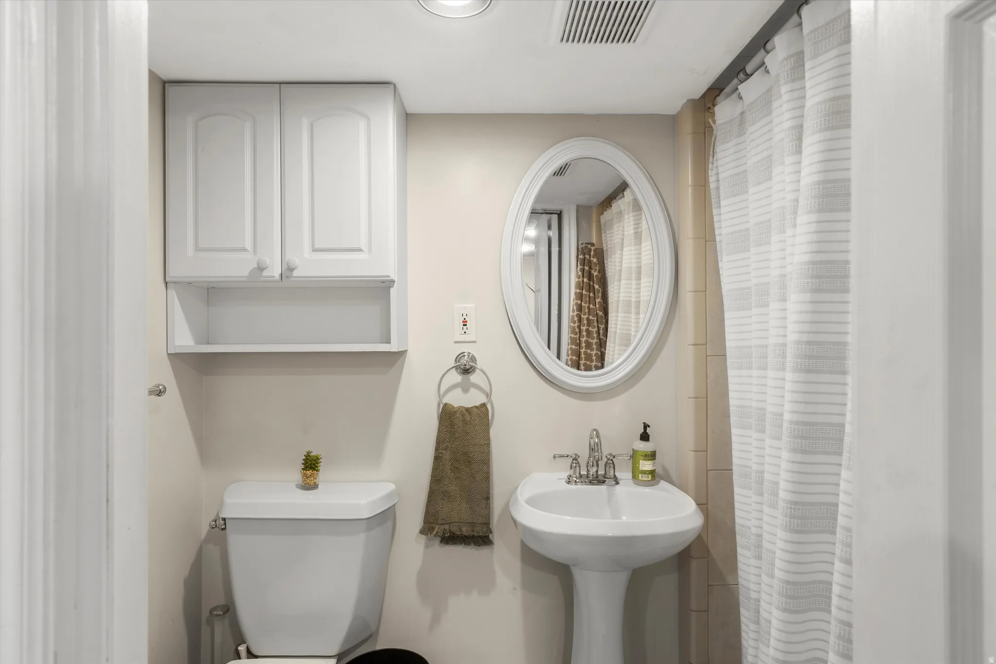 Full bathroom featuring toilet and a shower with curtain