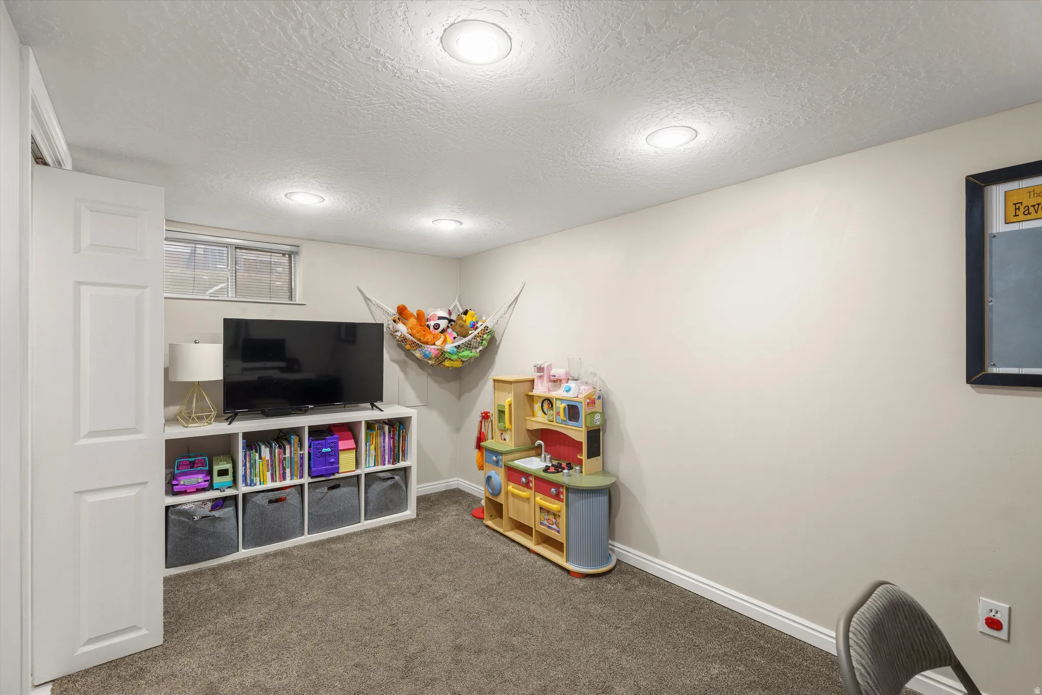 Playroom featuring a textured ceiling and carpet floors