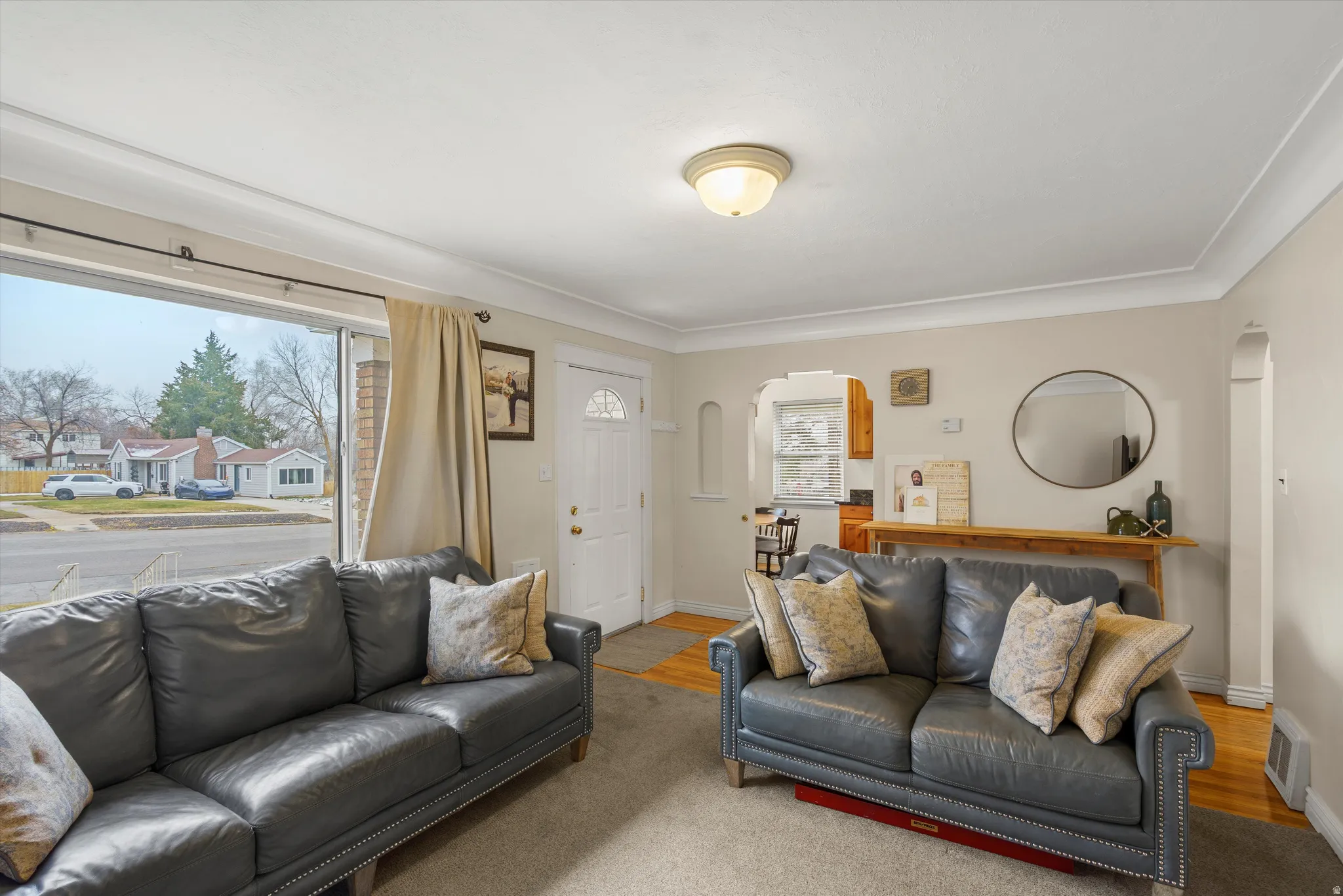 Living room with arched walkways and wood finished floors