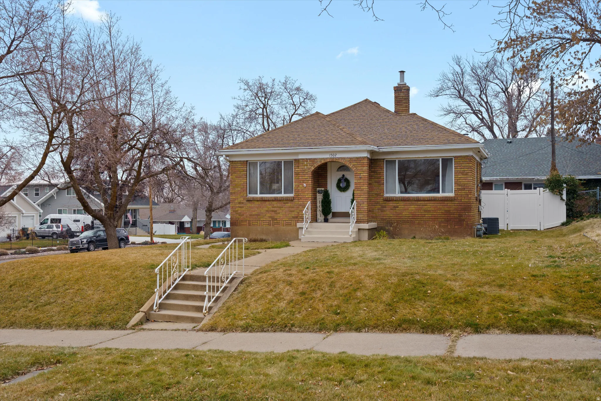 Bungalow featuring brick siding, a chimney, and roof with shingles
