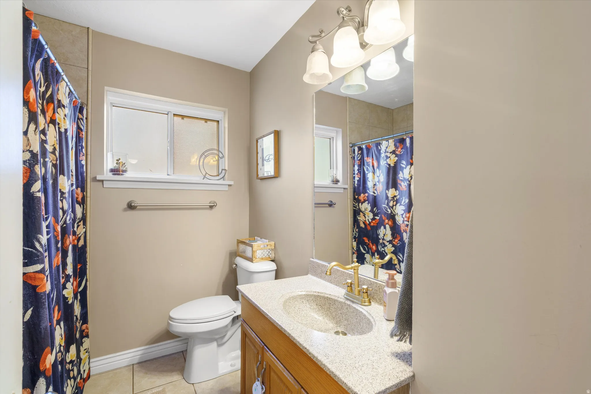 Full bath with vanity, light tile patterned flooring, and curtained shower
