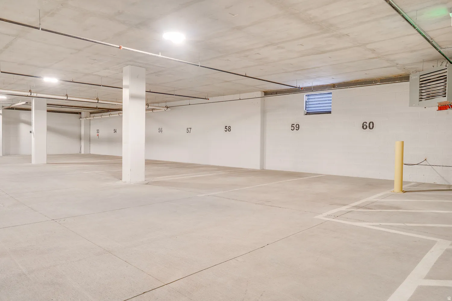 Parking garage featuring a heating unit and concrete block wall