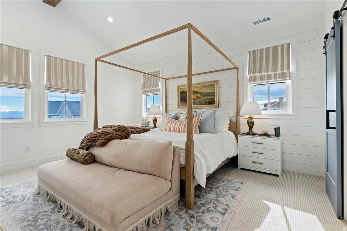 Bedroom featuring a barn door, carpet floors, vaulted ceiling, and recessed lighting