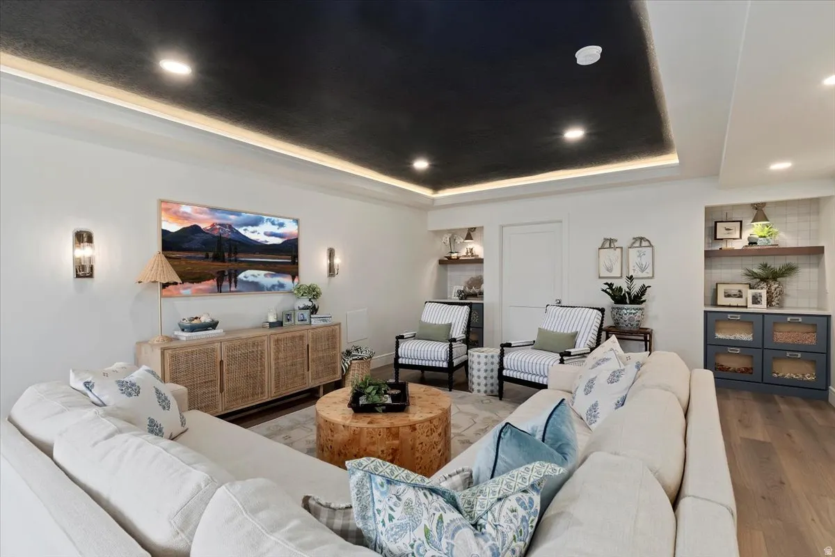 Living area featuring wood finished floors, recessed lighting, and a raised ceiling