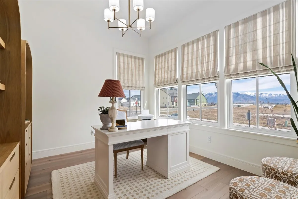 Home office featuring a mountain view, a chandelier, arched walkways, and light wood-style floors
