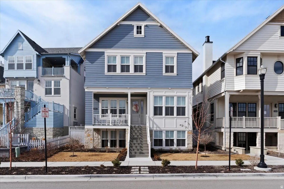 View of front of property featuring a balcony and stone siding