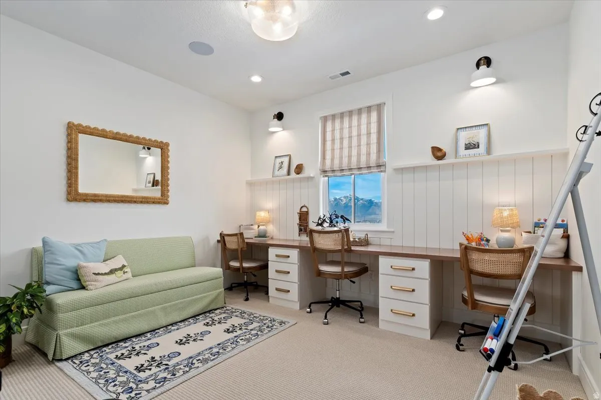 Office with built in desk, light carpet, a wainscoted wall, and recessed lighting