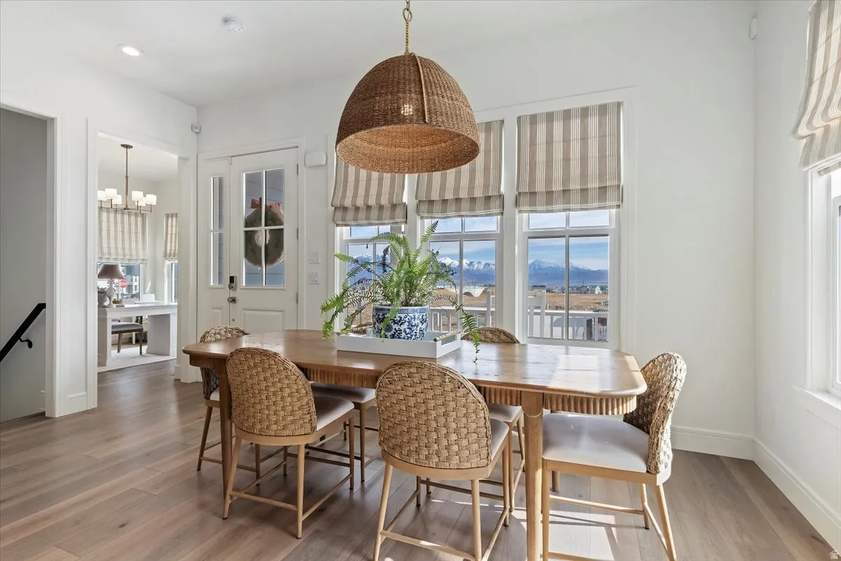 Dining space with a mountain view, light wood-style flooring, and a chandelier