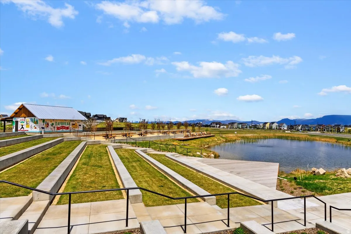 View of home's community with a water and mountain view and a game area
