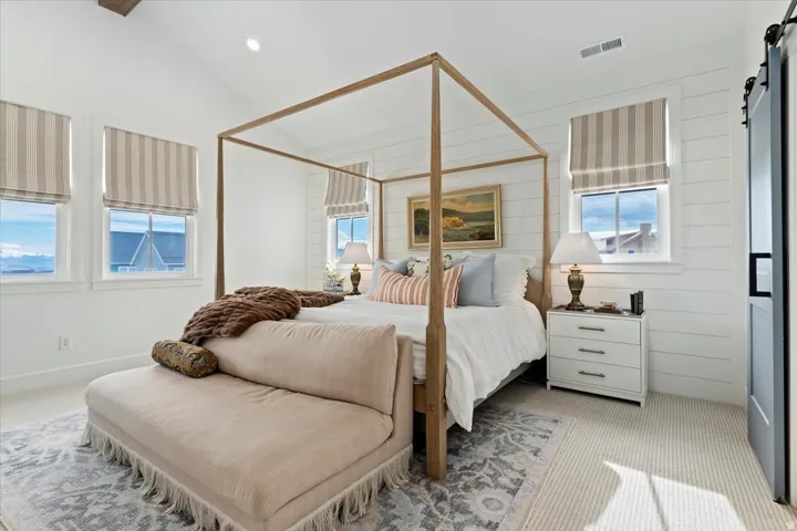 Bedroom featuring a barn door, carpet floors, vaulted ceiling, and recessed lighting