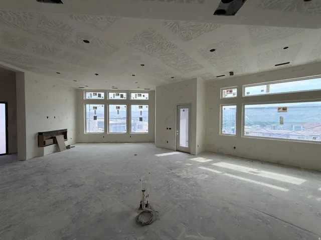 Spacious room with multiple large windows, recessed ceiling lighting, a built-in fireplace, and a glass-paneled door