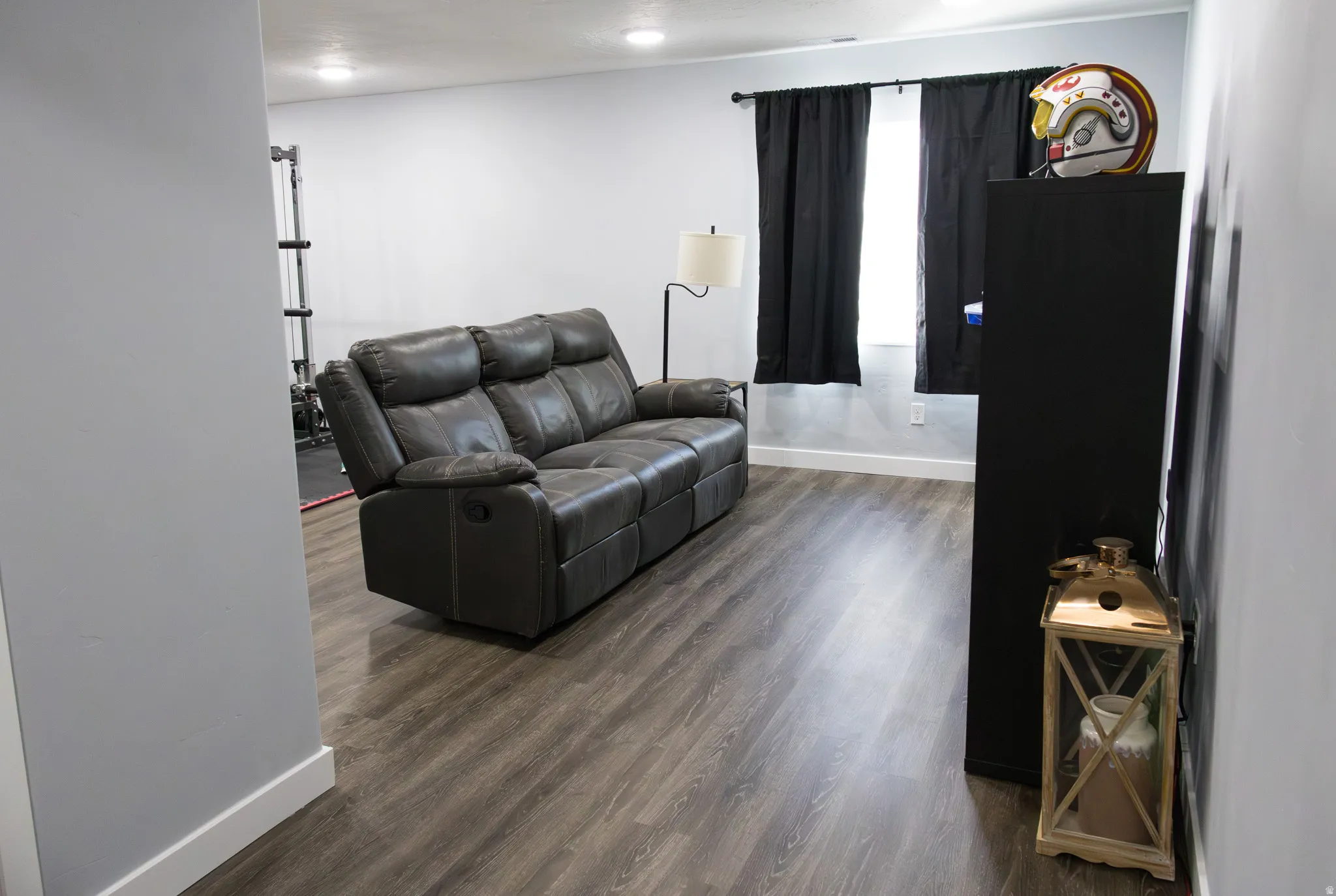 Living area with dark wood-style flooring and baseboards