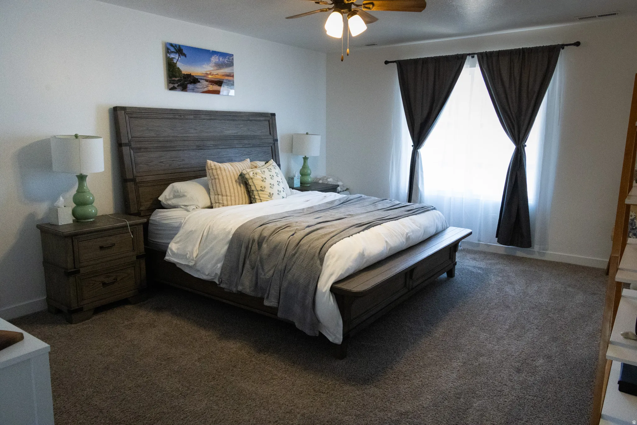 Bedroom with dark carpet and a ceiling fan
