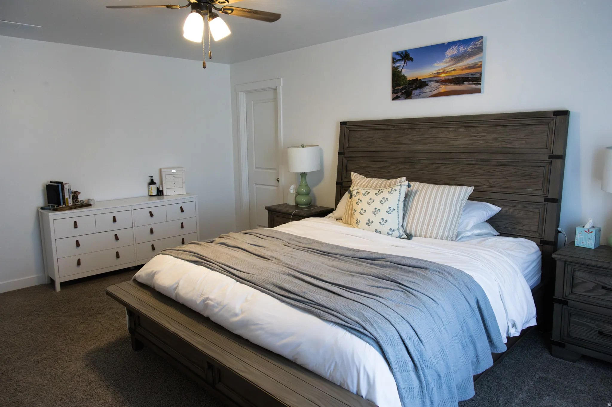Bedroom with dark colored carpet and a ceiling fan