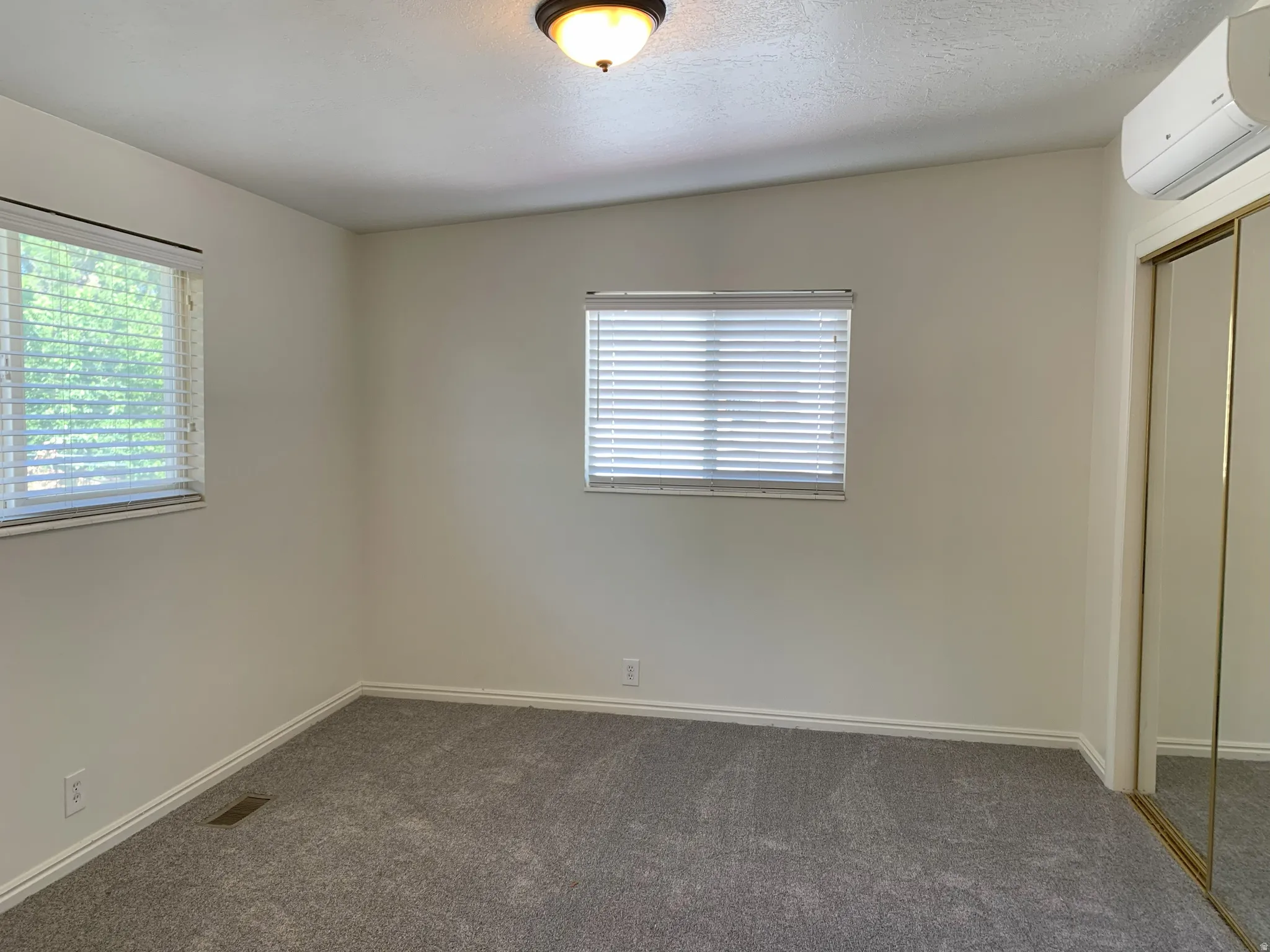 Unfurnished bedroom with a closet, dark carpet, and a textured ceiling