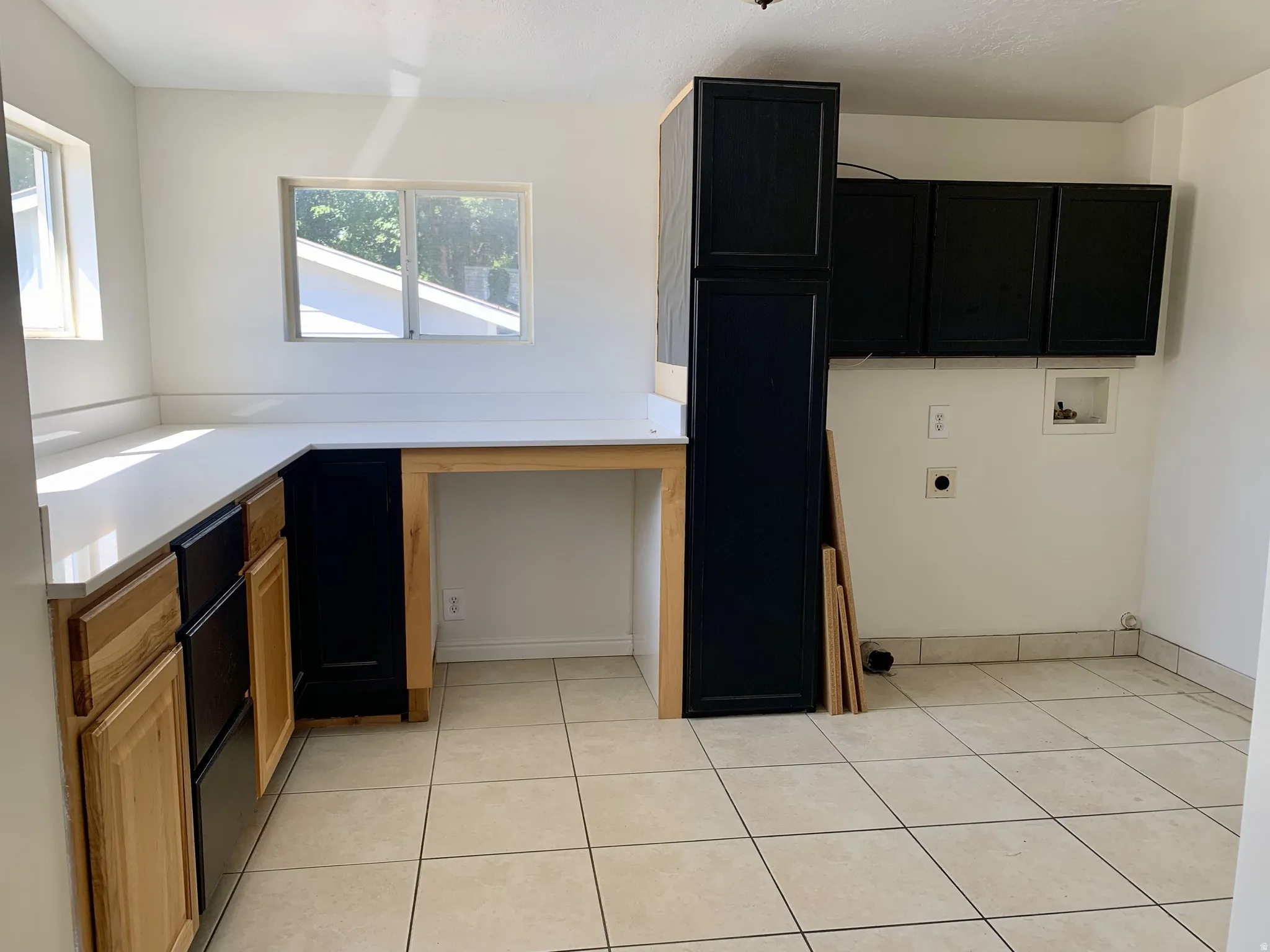 Laundry room with cabinet space, hookup for an electric dryer, hookup for a washing machine, and light tile patterned floors