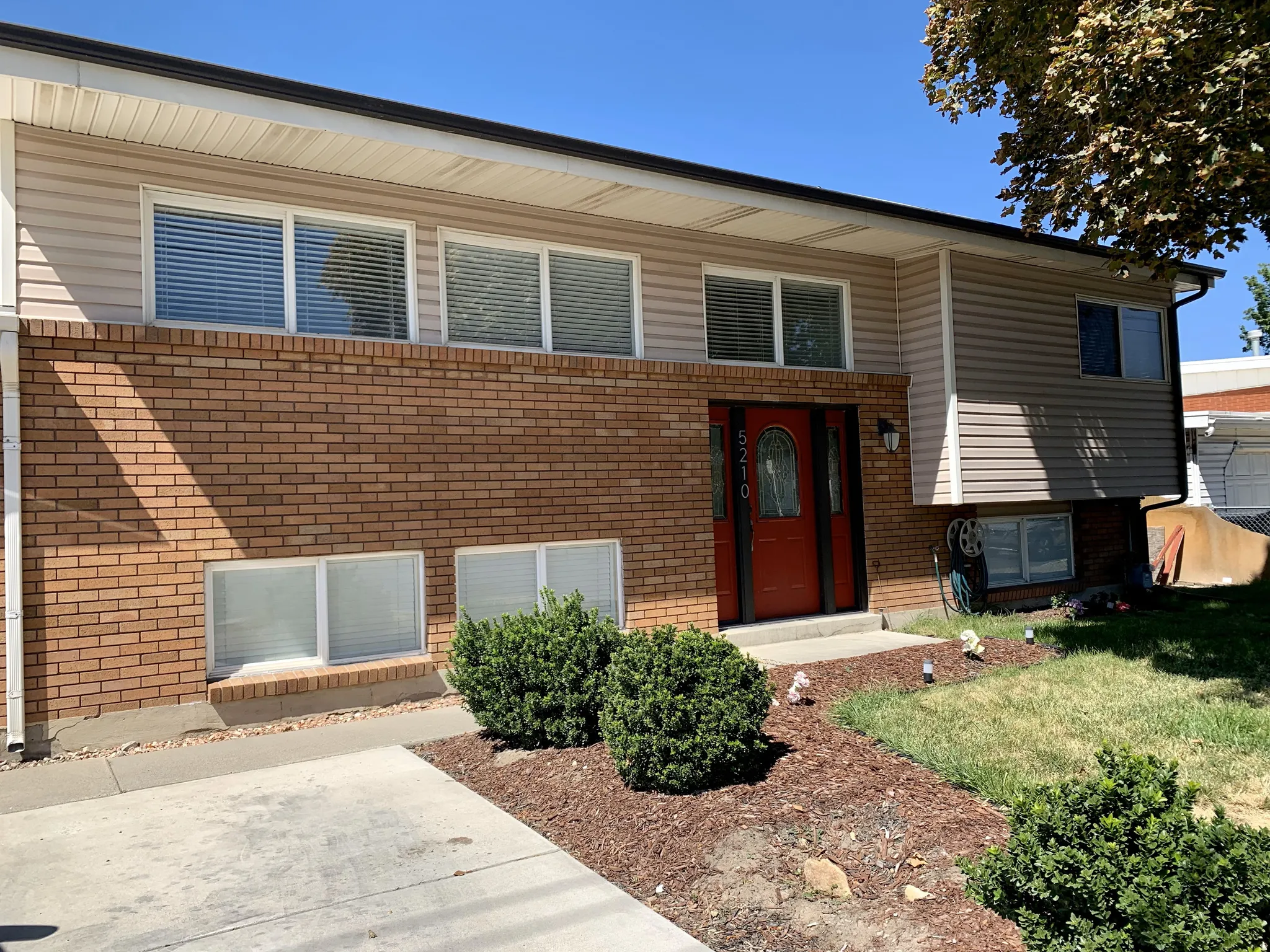 Raised ranch with brick siding and a front yard