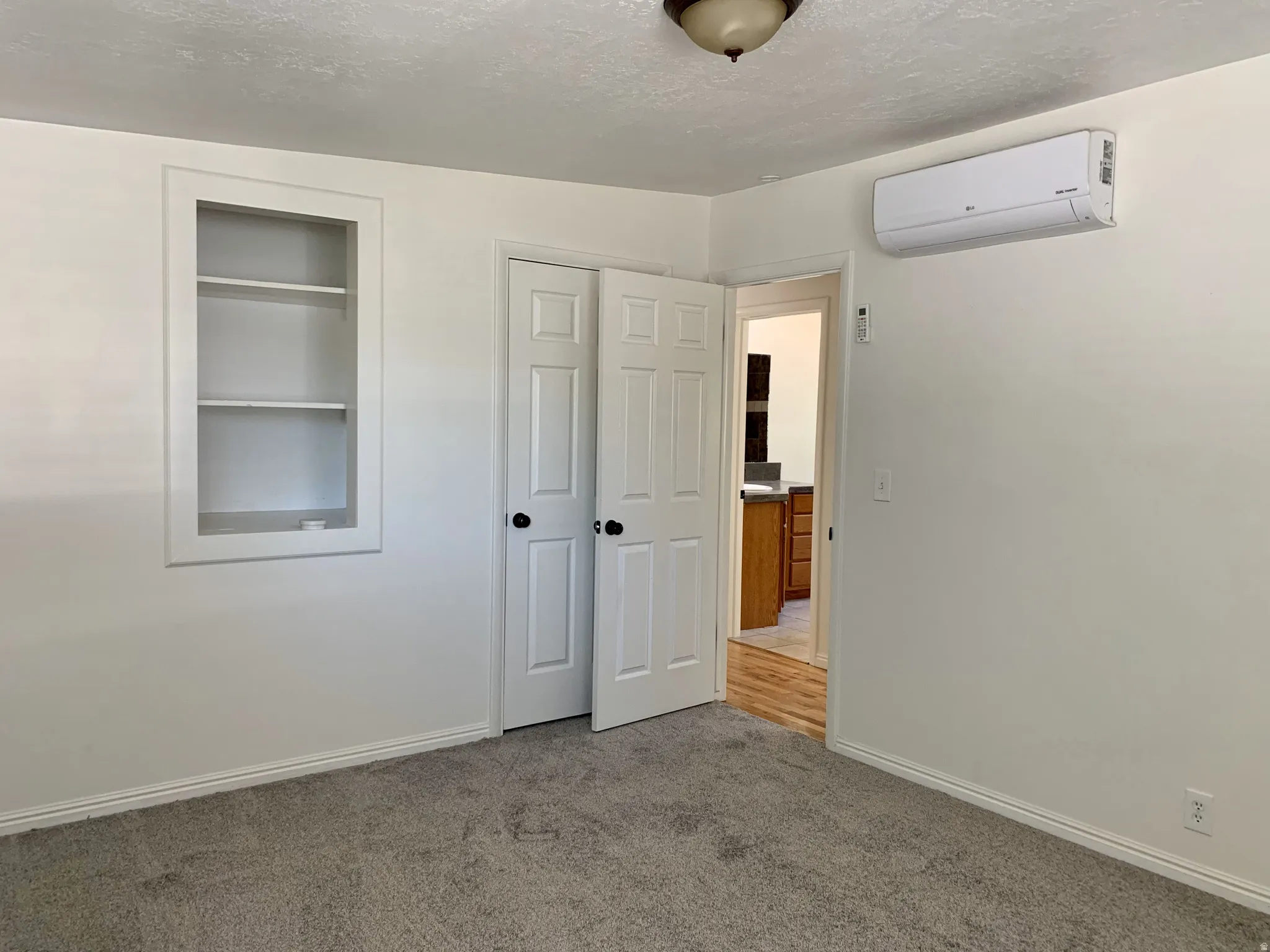 Unfurnished bedroom with carpet flooring, a textured ceiling, and a closet