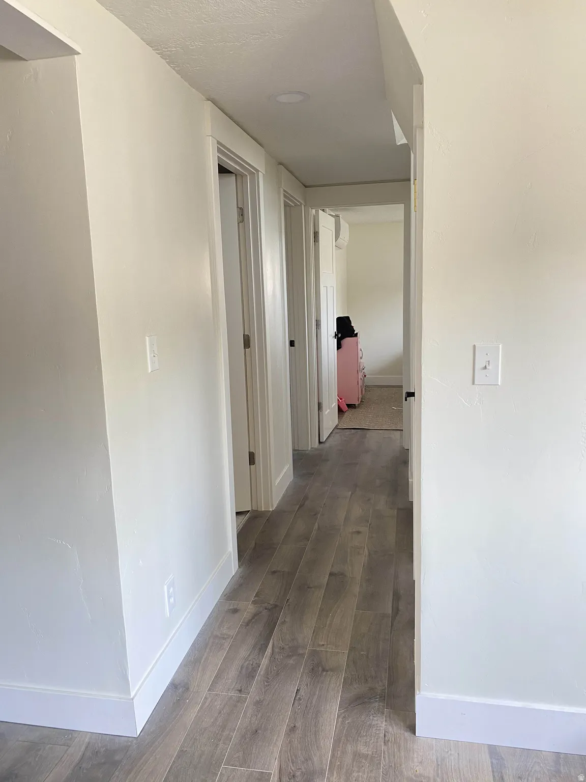Hall with dark wood finished floors and baseboards