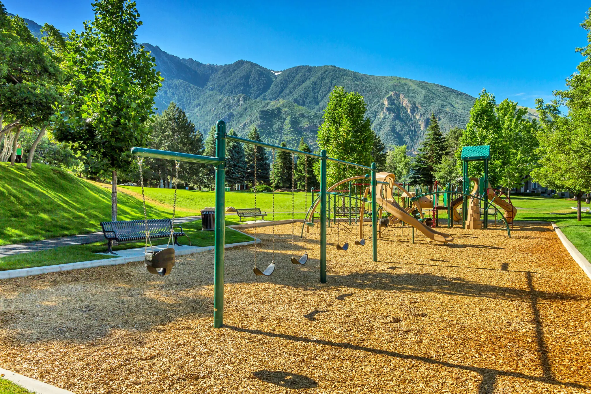 Communal playground with a lawn and a mountain view