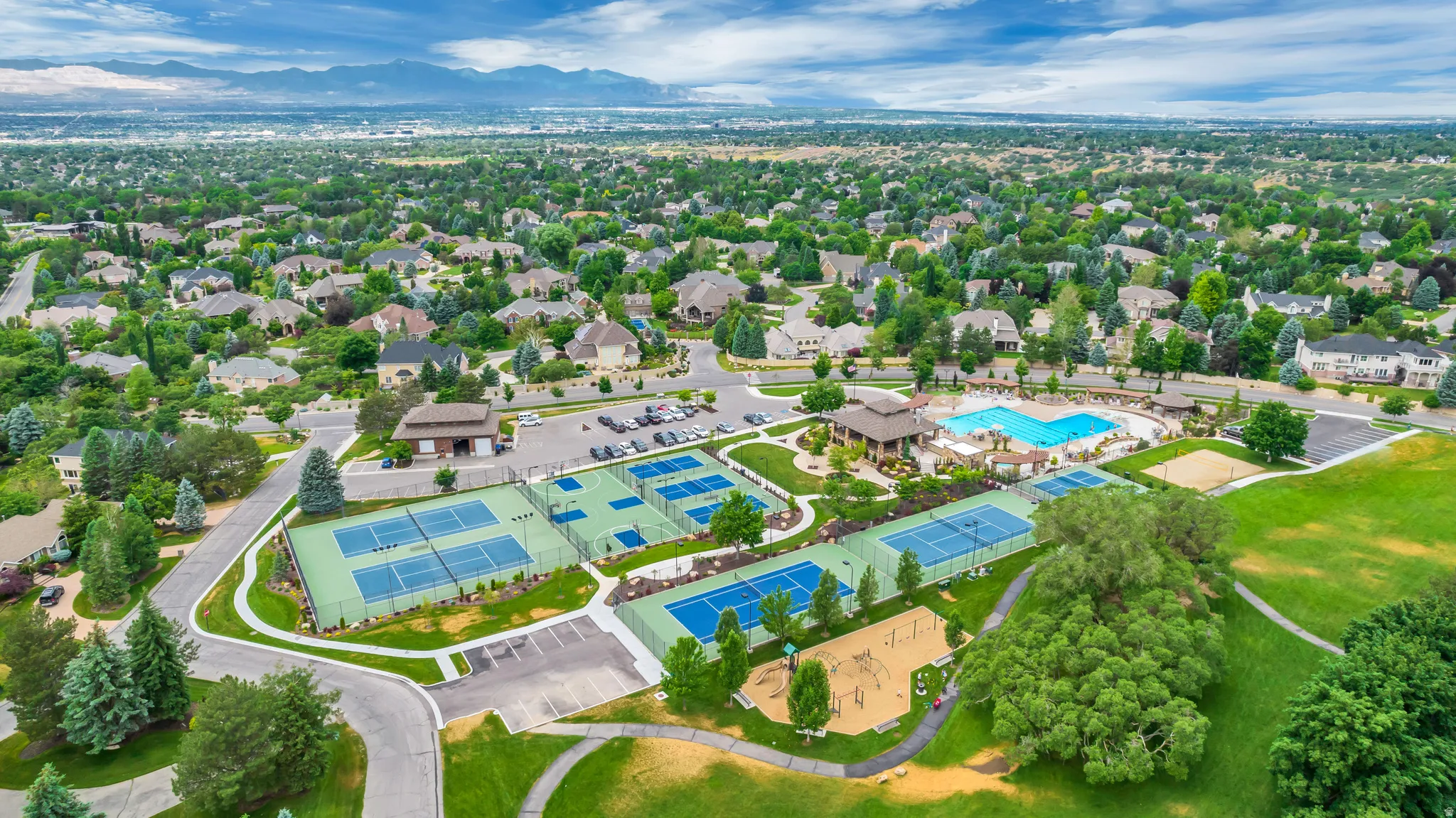Aerial perspective of suburban area with a pool and a mountainous background