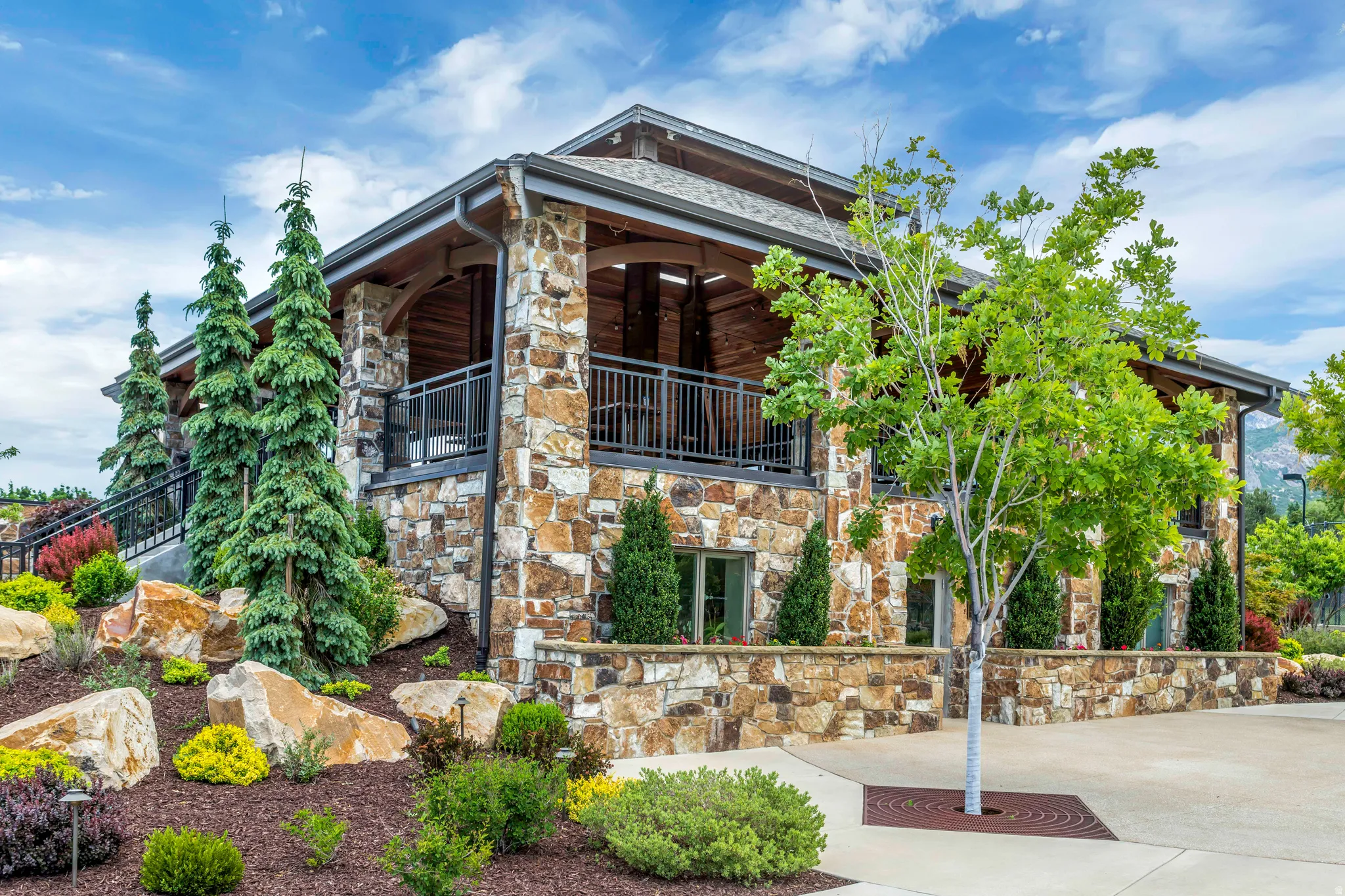View of front of property with stone siding and a balcony