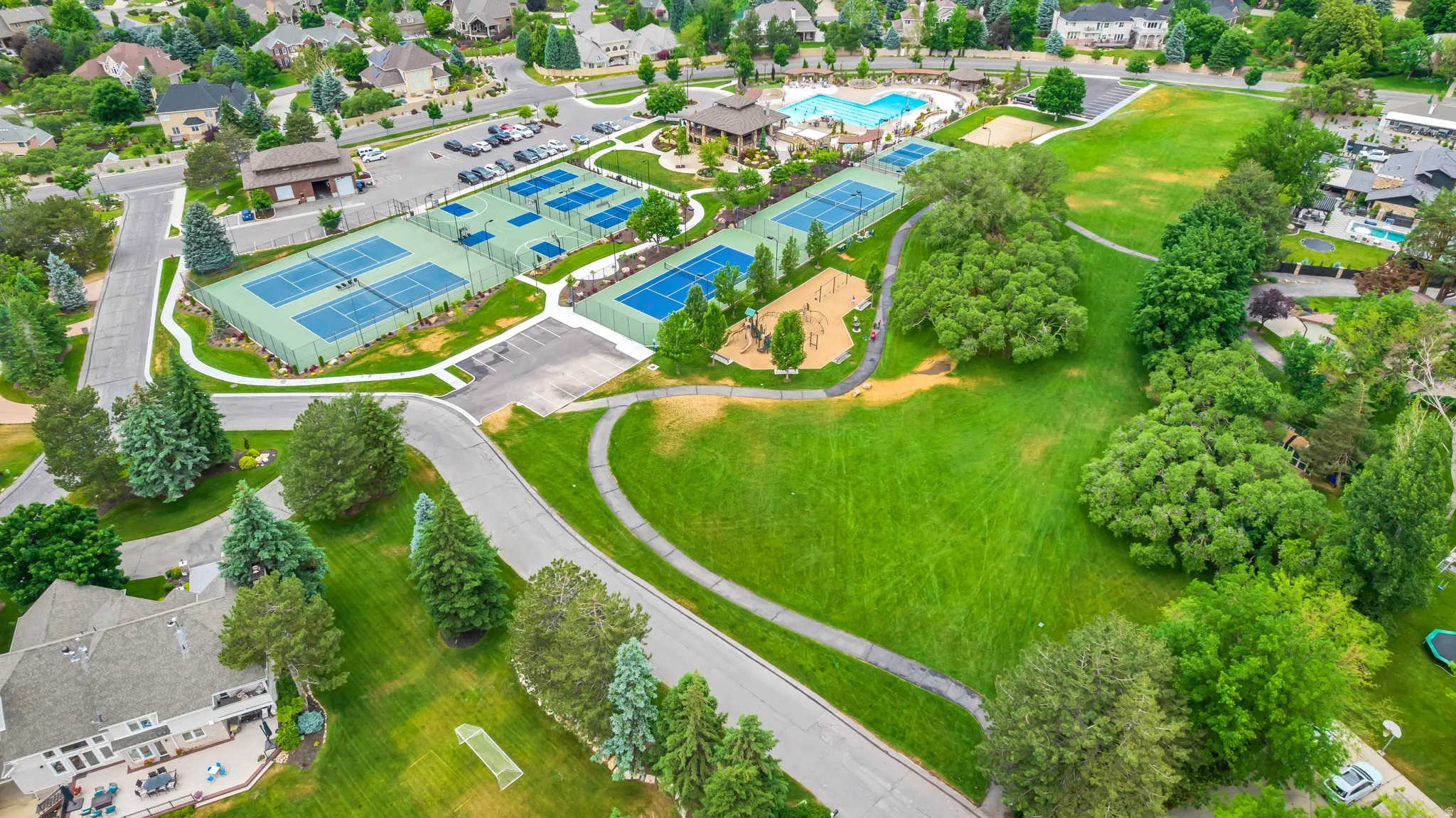 Aerial overview of property's location featuring a pool and nearby suburban area
