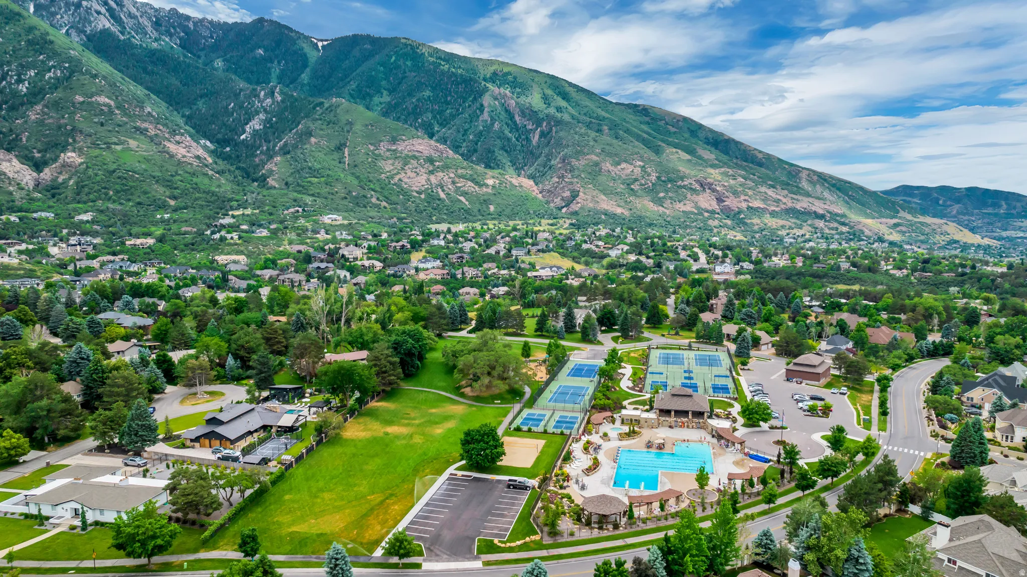 Aerial view of residential area featuring mountains and a pool
