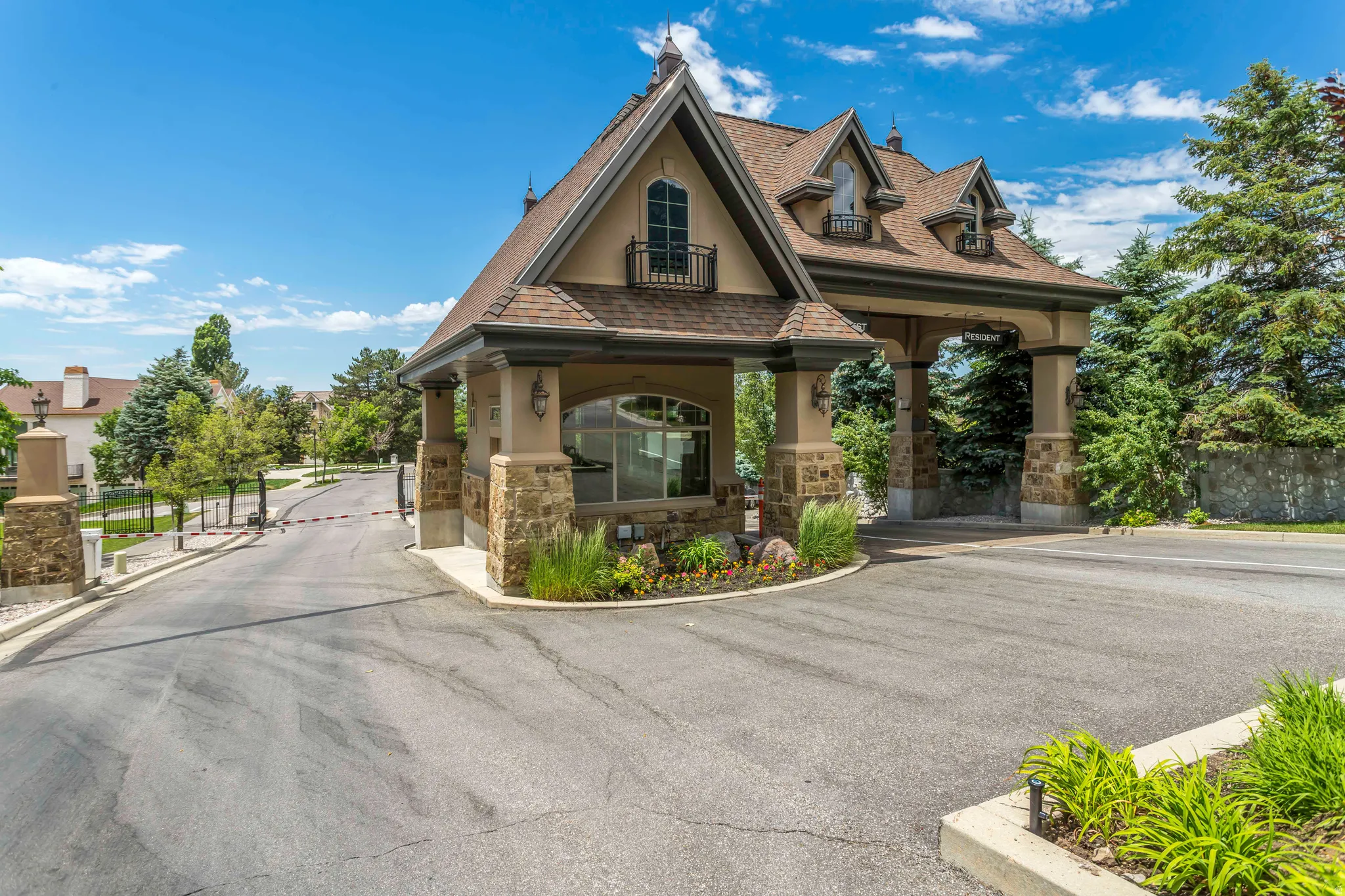 View of asphalt street with curbs and a gated entry
