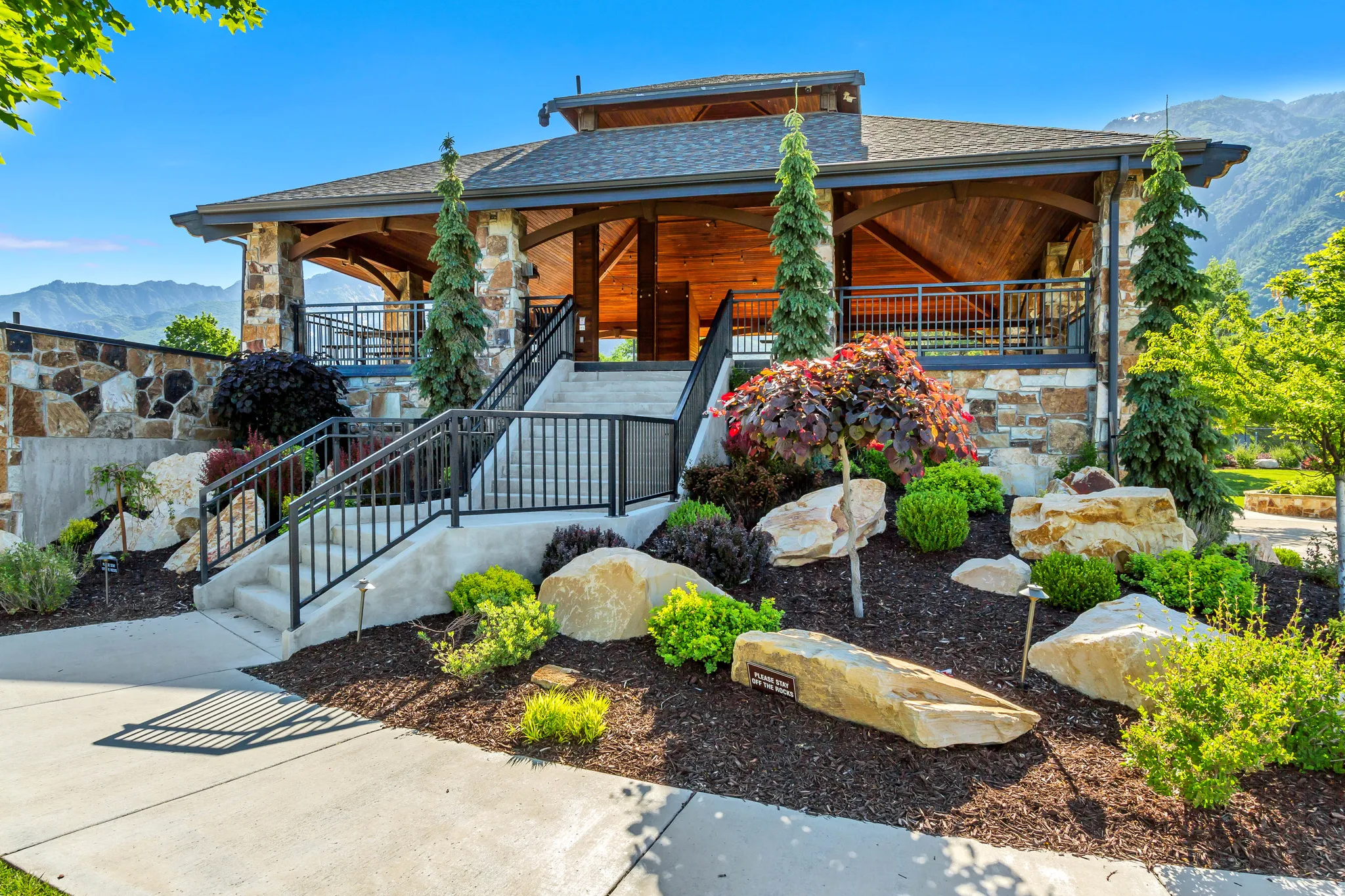 View of front of house with a mountain view, roof with shingles, covered porch, and stone siding