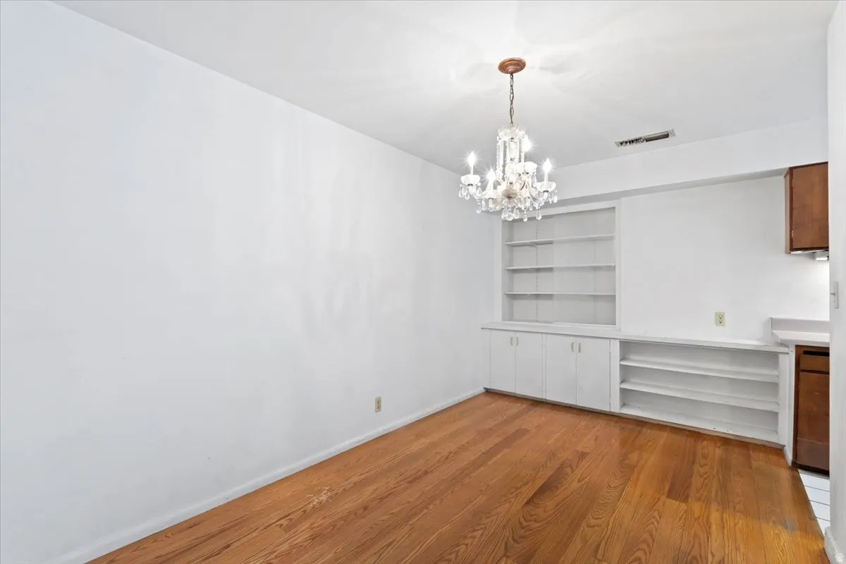 Hardwood flooring throughout, complemented by a crystal chandelier