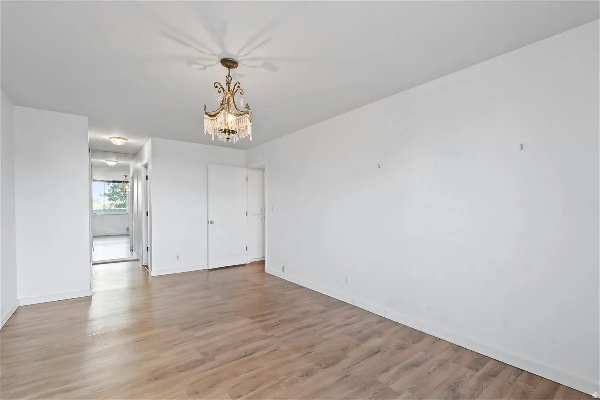 Unfurnished bedroom with hanging lights and light wood-style flooring