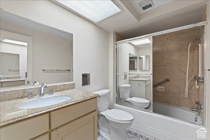 Bathroom featuring bath / shower combo with glass door and vanity