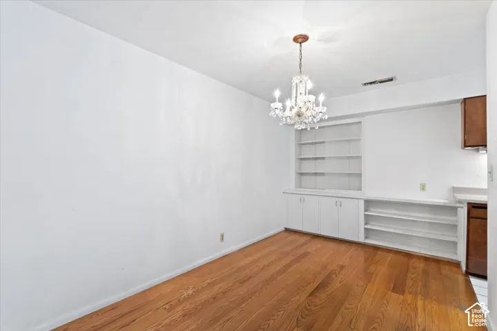 Hardwood flooring throughout, complemented by a crystal chandelier