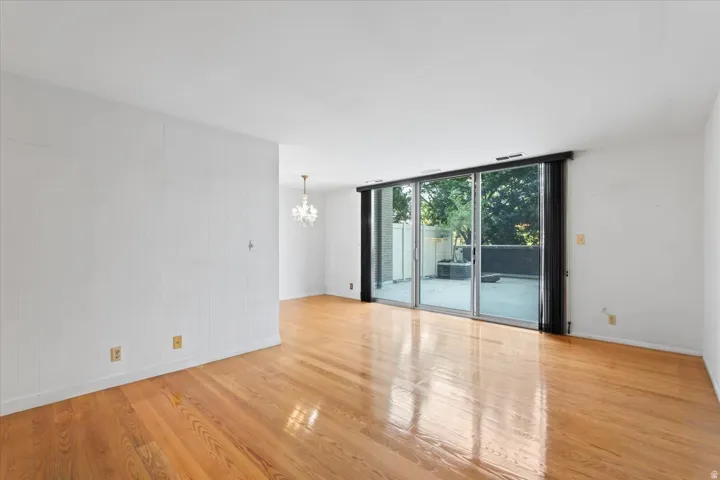 Expansive room featuring wood-finish flooring, white walls, and a full wall of sliding glass doors