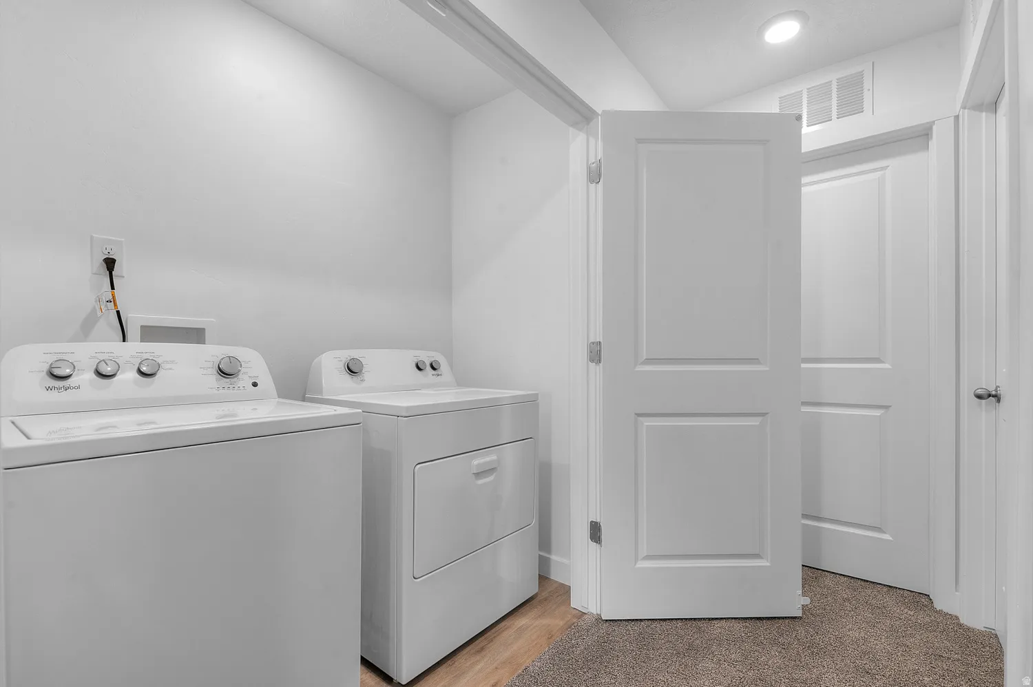 Laundry area featuring washing machine and clothes dryer and light wood-style floors
